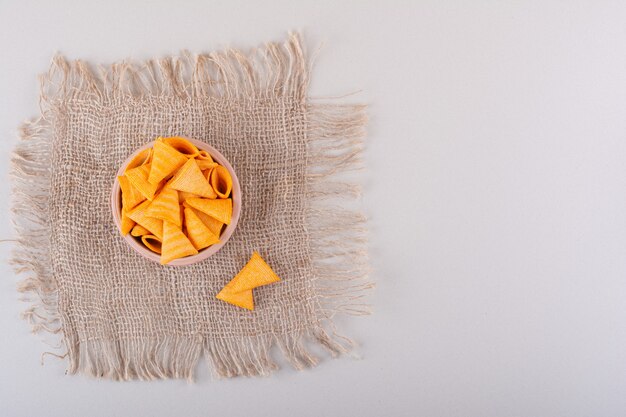 Bowl of triangle crispy chips placed on marble background. High quality photo