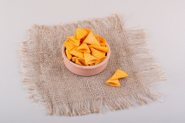 Bowl of triangle crispy chips placed on marble background. High quality photo