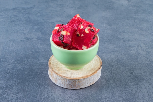 A bowl of Turkish delights on a board , on the marble background.