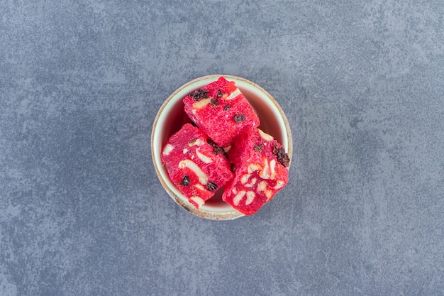 A bowl of Turkish delights on a board on the marble surface