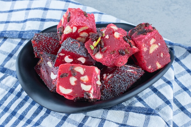 Free photo a bowl of turkish delights, on the tea towel , on the marble table.