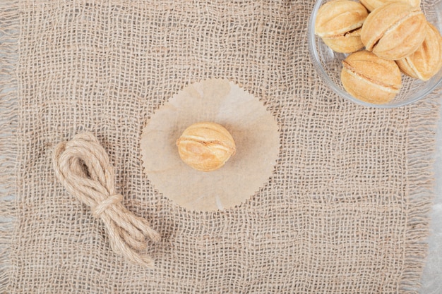 Free photo bowl of walnut shaped cookies in glass bowl on burlap. high quality photo