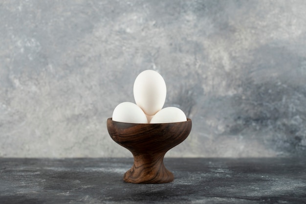 Bowl of white eggs on marble surface. 