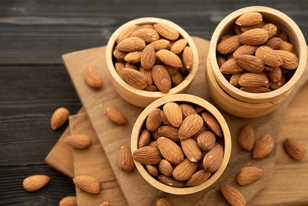 Bowl with almond on a wooden table.