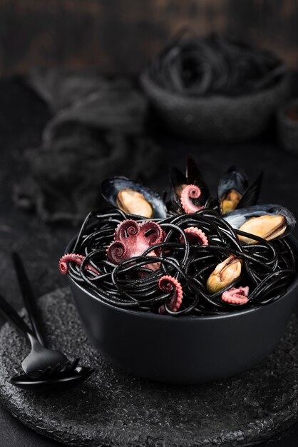 Bowl with black spaghetti and mussels