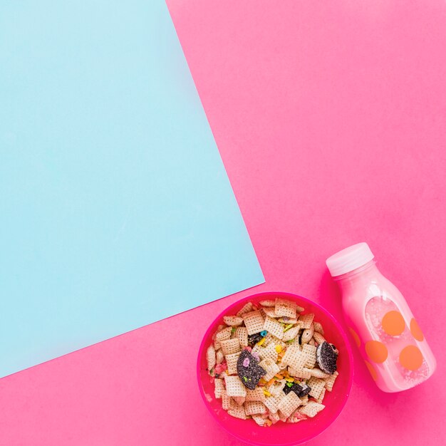 Bowl with cereals and pink milk bottle