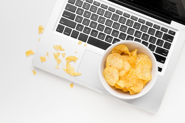 Bowl with chips on laptop
