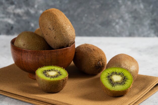 Bowl with delicious kiwi fruits on brown tablecloth 