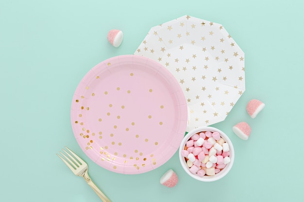 Bowl with jellies beside plates on table