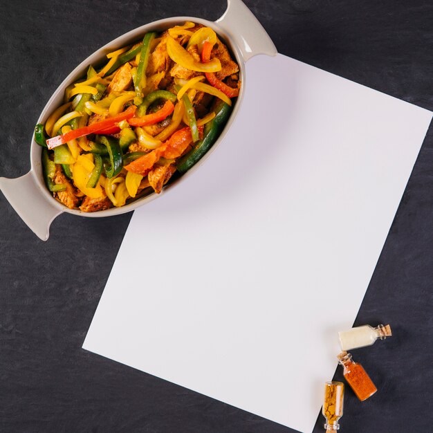 Bowl with Mexican food near paper sheet