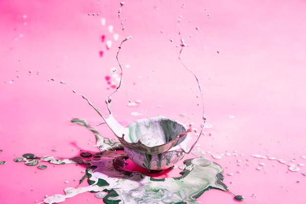 Bowl with mixed paint and pink background