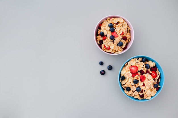 Bowl with muesli and blueberries on grey background with copyspace