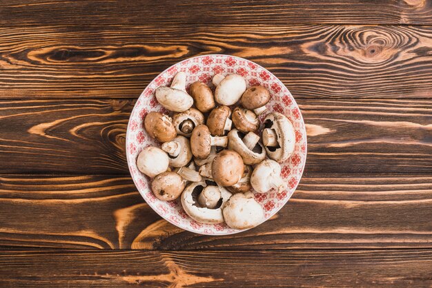 Bowl with mushrooms on wooden tabletop