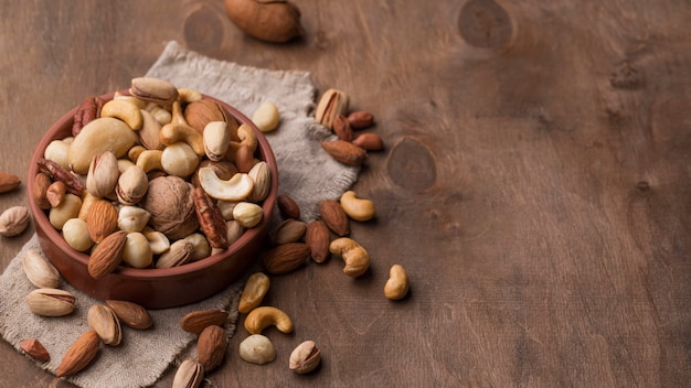 Bowl with nuts copy space wooden background