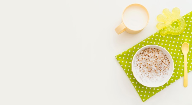 Bowl with oat flakes and glass of milk with copy-space