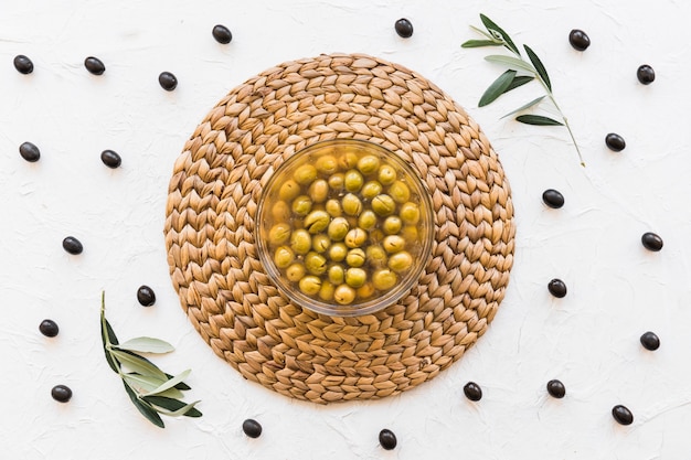 Bowl with olives and oil on corset with white backdrop