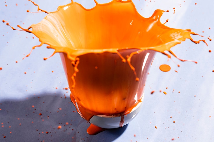 Free Photo bowl with orange paint and violet background