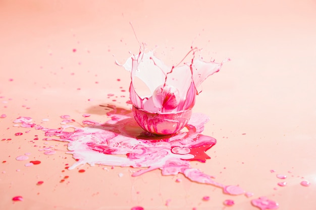 Чаша с розовой краской и персиковым фоном