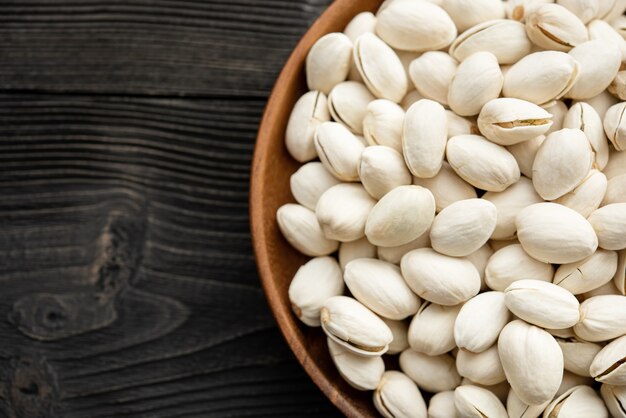 Bowl with pistachios on a wooden table.