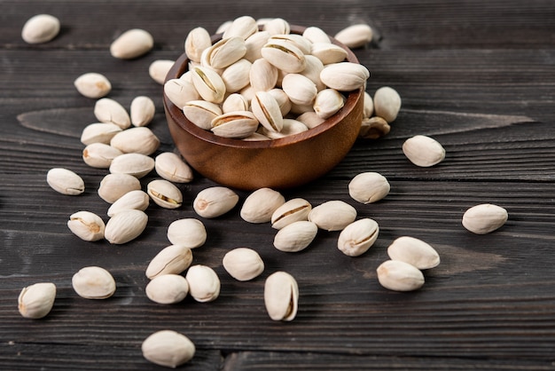 Bowl with pistachios on a wooden table.