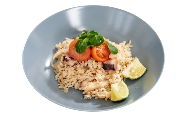 Bowl with riceseafoodjuicy tomatoes and two pieces limes