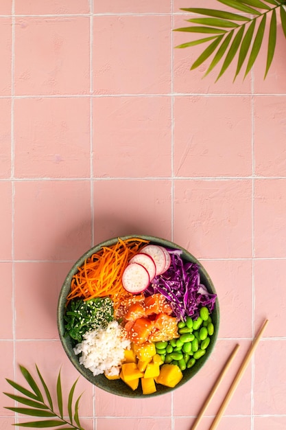 Bowl with salmon rice and fresh vegetables poke top view Vertical
