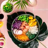 Free photo bowl with salmon rice and fresh vegetables poke top view