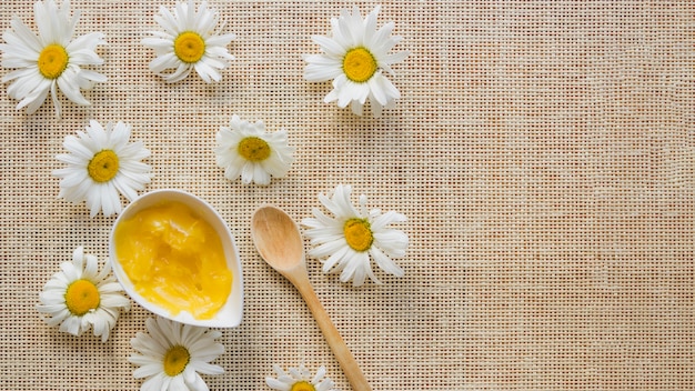 Bowl with shea butter, spoon and camomiles