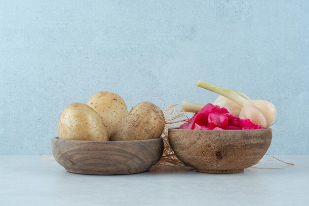 Bowls of boiled potatoes and pickled red cabbage with garlic.