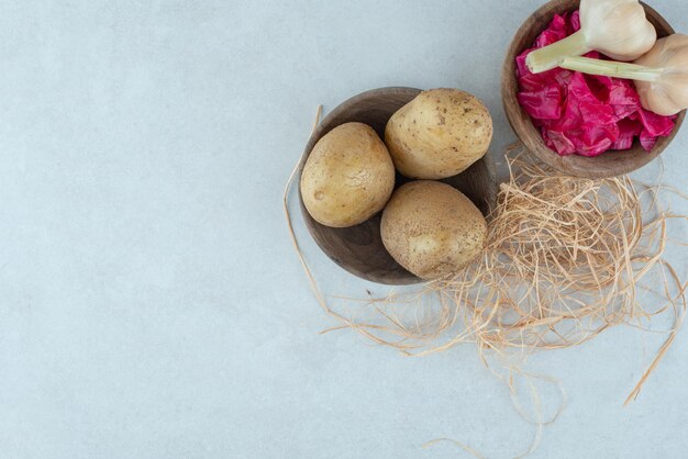 Bowls of boiled potatoes and pickled red cabbage with garlic.