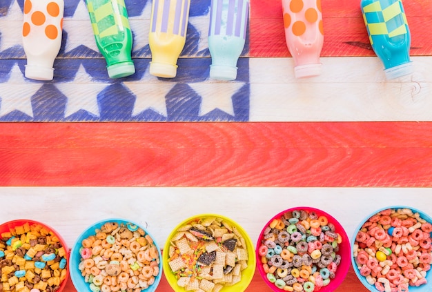 Bowls of cereals with milk bottles on table