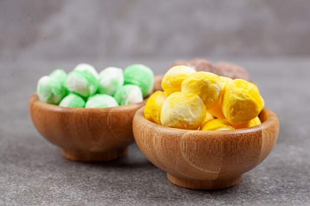 Bowls of colorful candies on marble surface
