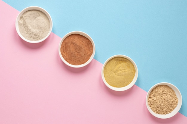 Bowls filled with coloured sand flat lay