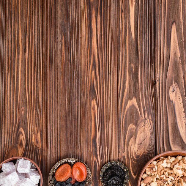 Bowls of lukum; earthen nuts and dried fruits on the wooden backdrop with copy space for writing the text