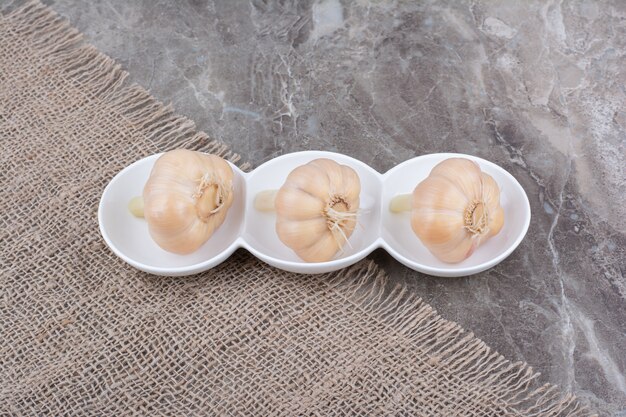 Bowls of tasty pickled garlic on burlap.