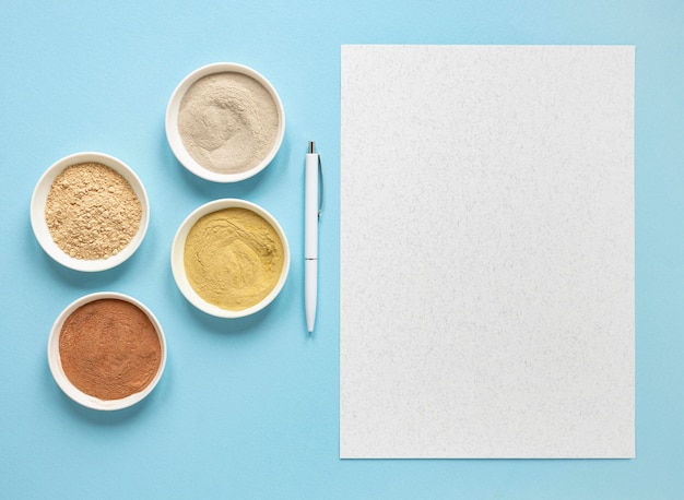 Bowls with coloured sand and copy space paper