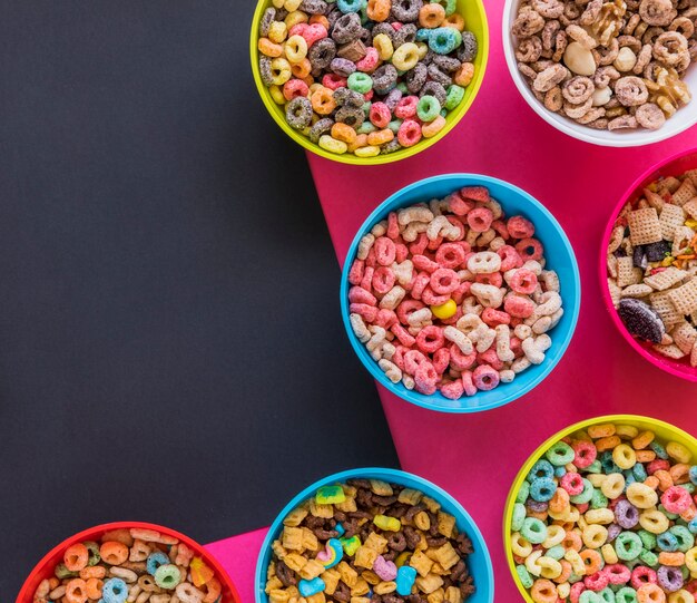 Bowls with different cereals on bright table