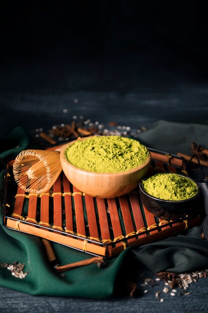 Bowls with green matcha on wooden tray 