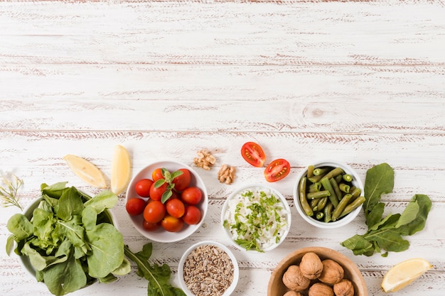 Bowls with healthy food on wooden background