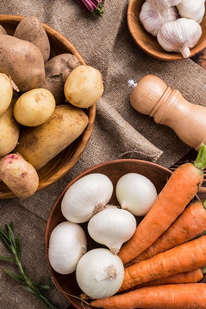 Bowls with potatoes carrot and garlic