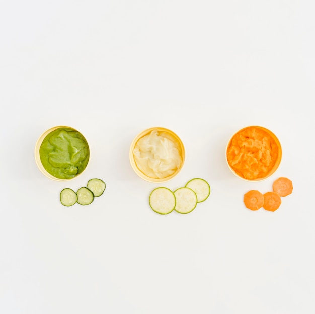 Bowls with vegetables puree for baby on table