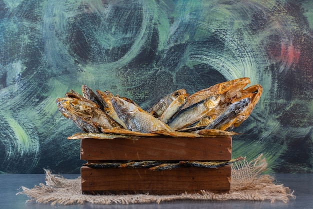 Box of dried fish on a burlap napkin on the marble surface