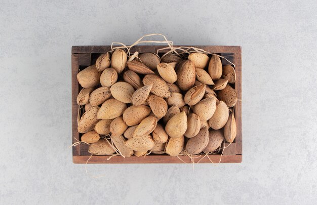 The box is full of almonds on the marble surface