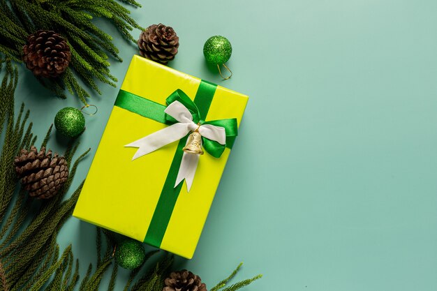 Box of present with bow on light green background