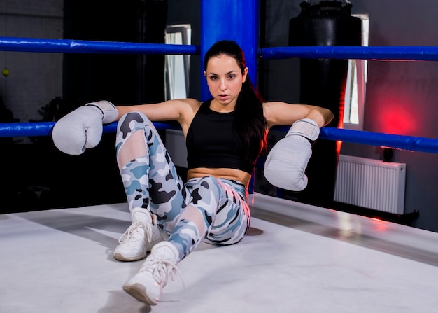 Ragazza del pugile che posa in palestra