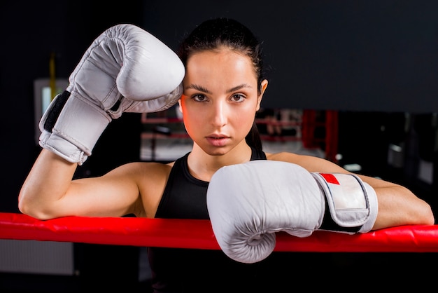 Ragazza del pugile che posa in palestra