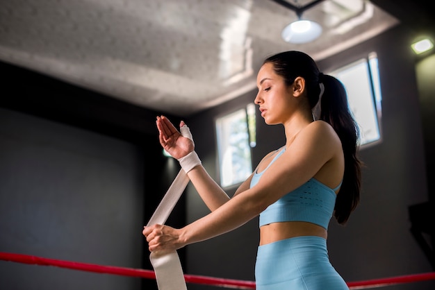 Ragazza del pugile che posa in palestra