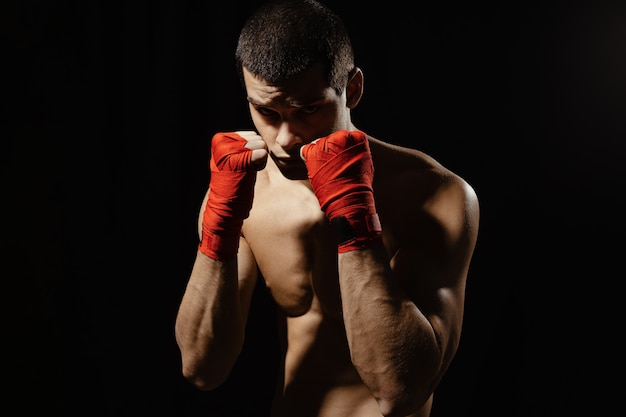 Boxer male fighter posing in confident defensive stance with hands in bandages up