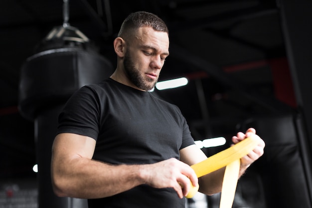 Boxer man holding elastic cord