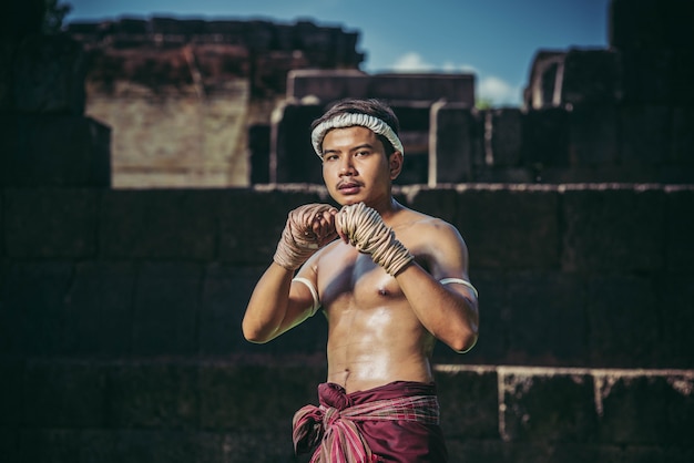 Free photo a boxer tied a rope in his hand and performed a fight, the martial arts of muay thai.